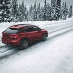 Red Lexus RX 350 driving in snowy conditions